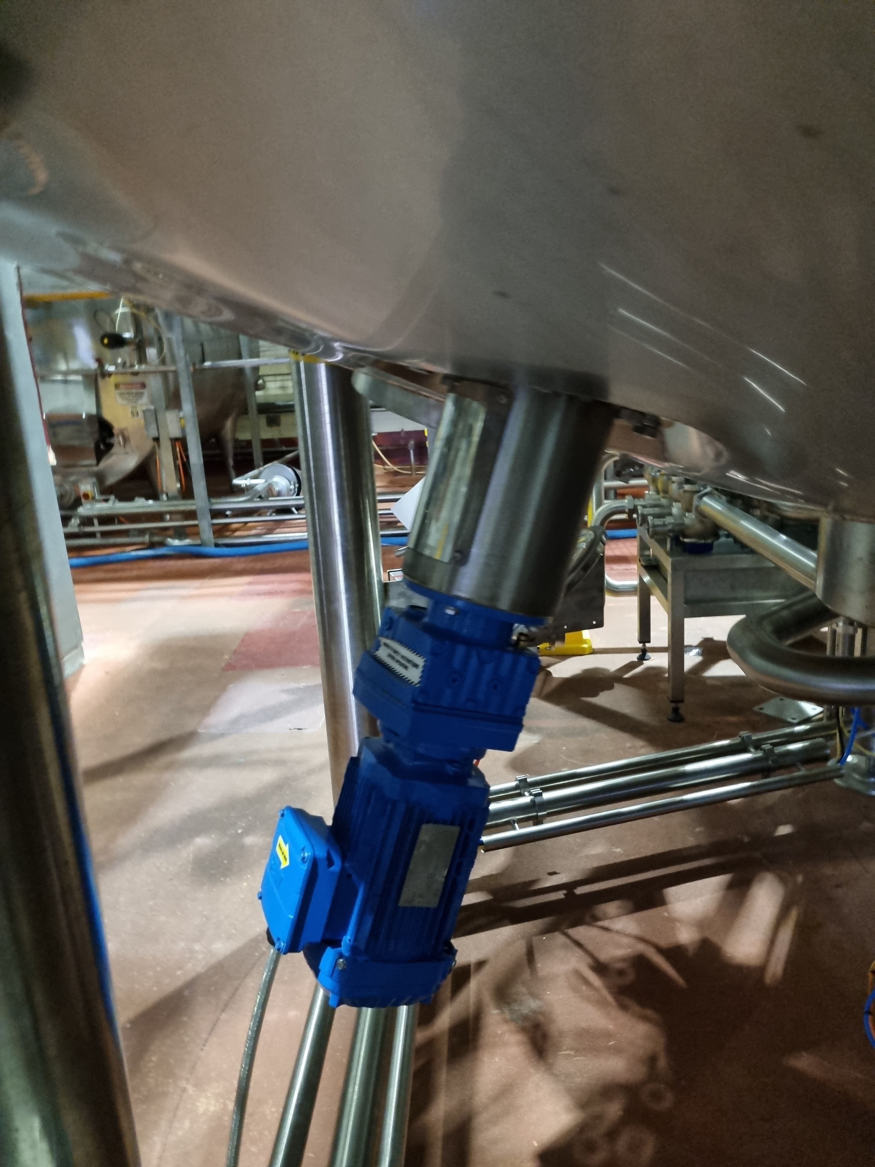 A base entry mixer with electric motor in blue mounted to a metal tank with sloping base and a frame.