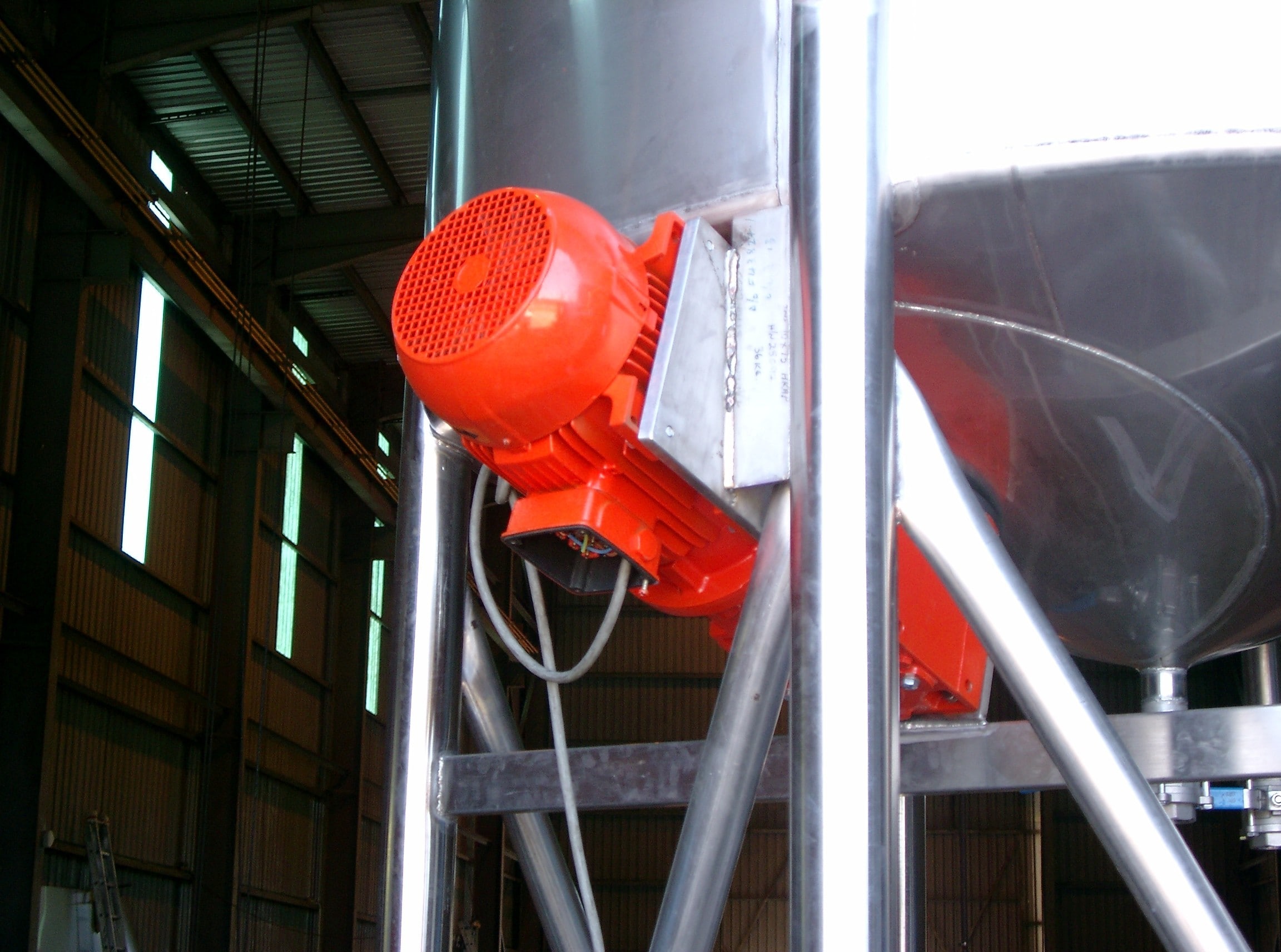 Bottom entry mixer mounted to the tank of a nutritional beverage processing manufacturer. Red flameproof motor is visible with plug and wire.