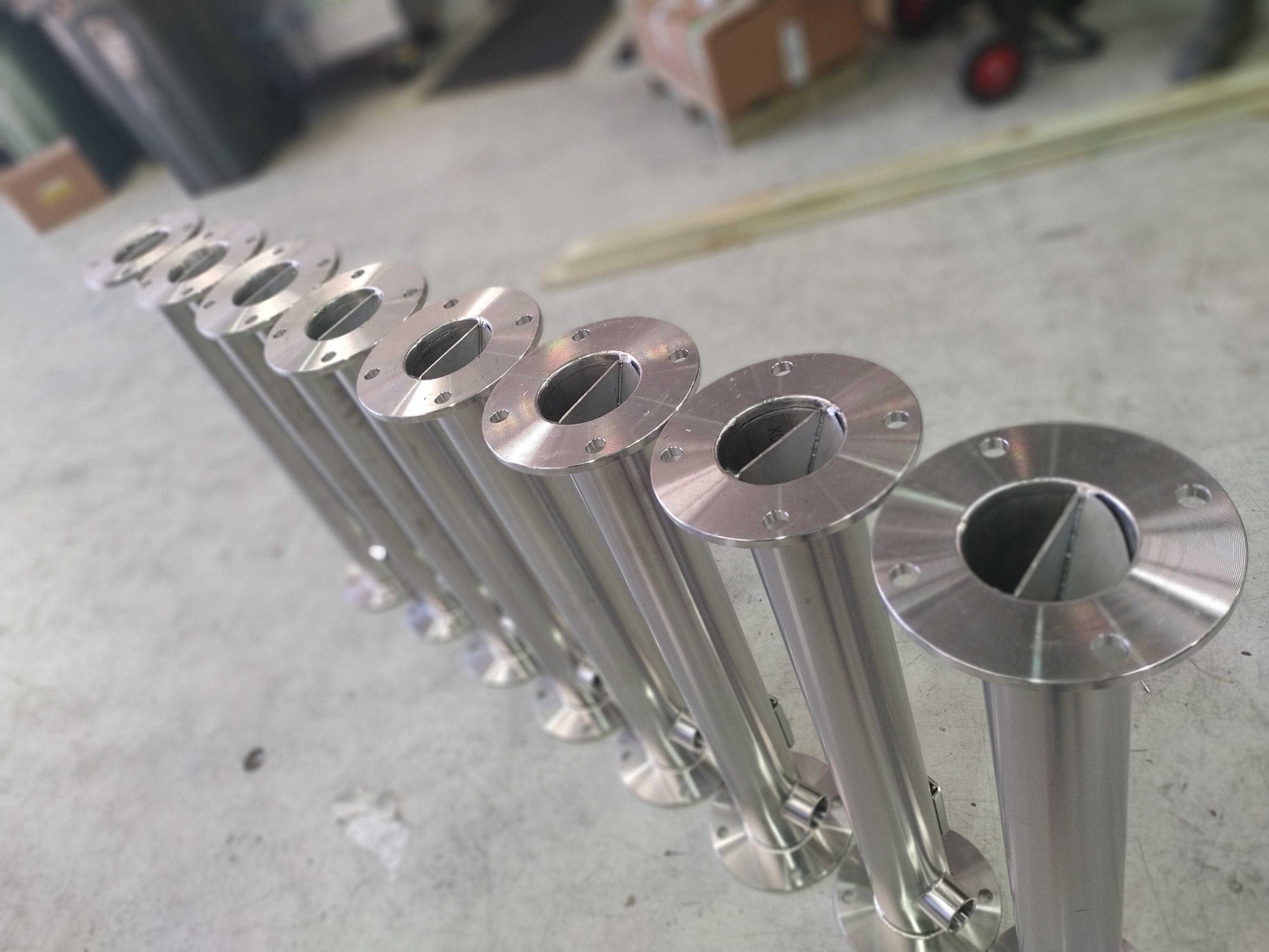 A row of stainless steel static mixers standing up. The mixer elements are visible.