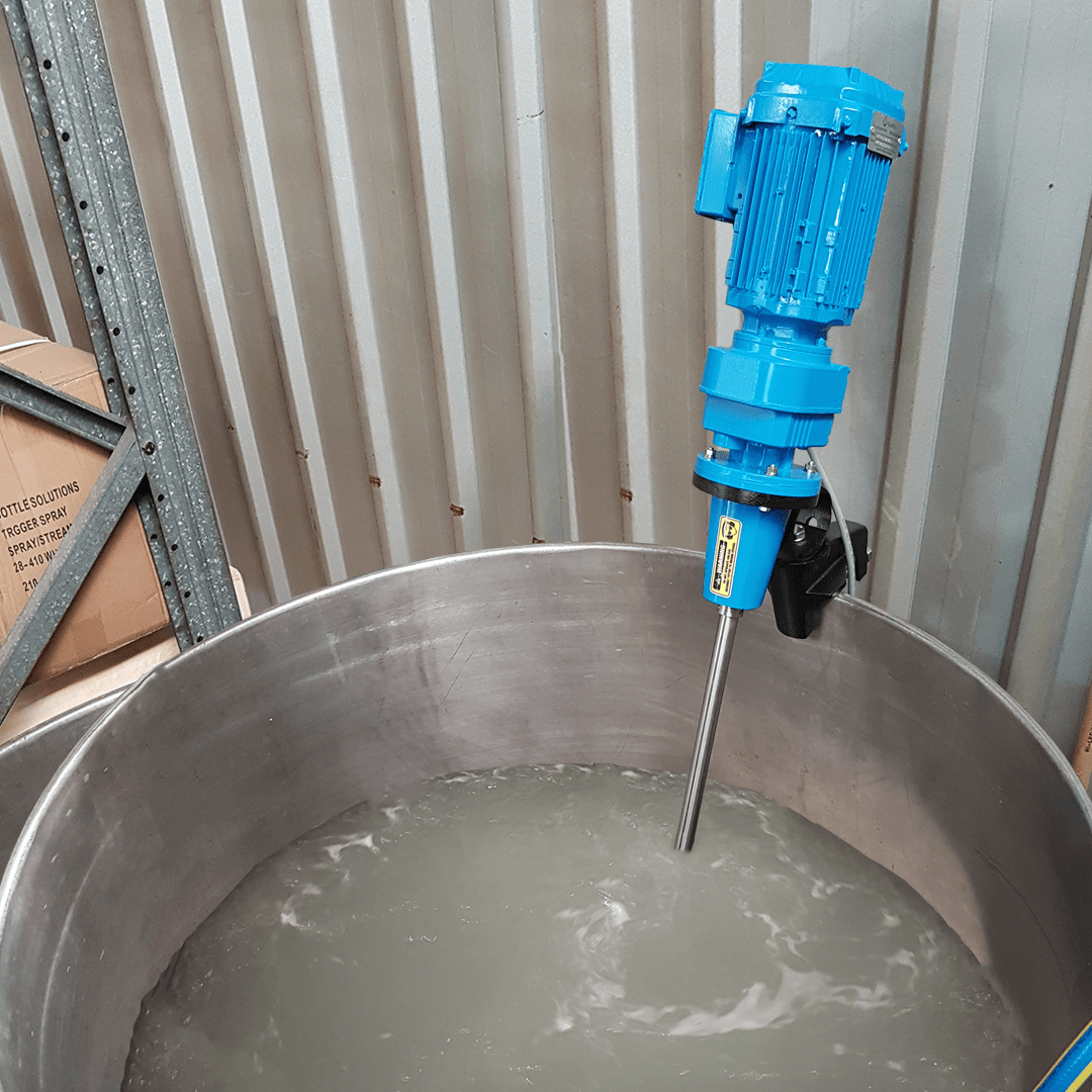 A FluidPro Clamp-On Mixer mounted to an open top tank via a heavy duty black cast aluminium clamp. Water is being agitated within the tank.