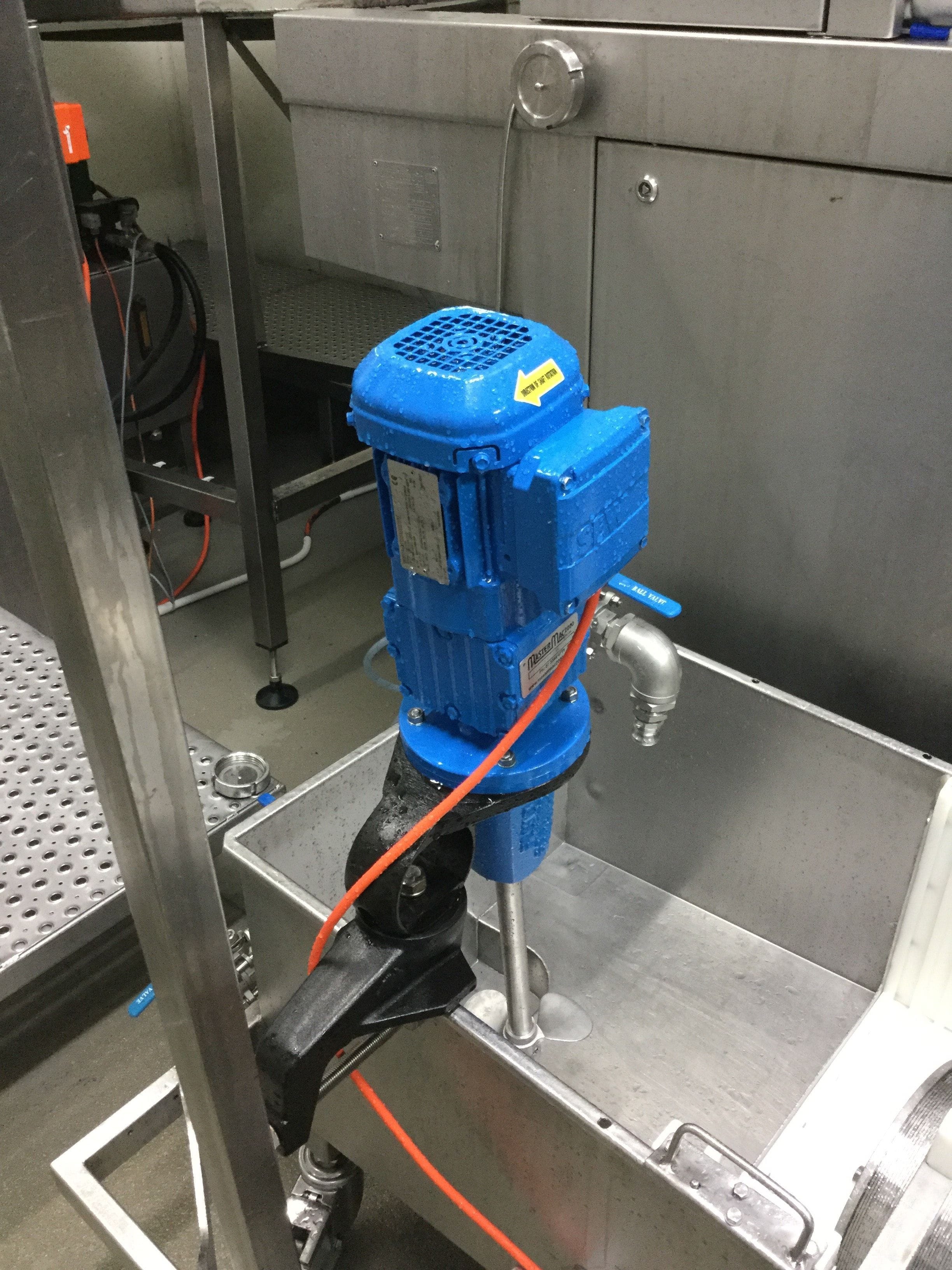 Clamp on mixer from FluidPro, attached to a horizontal tank or trough. An orange cable is visible connected to the electric motor of the PS-10.