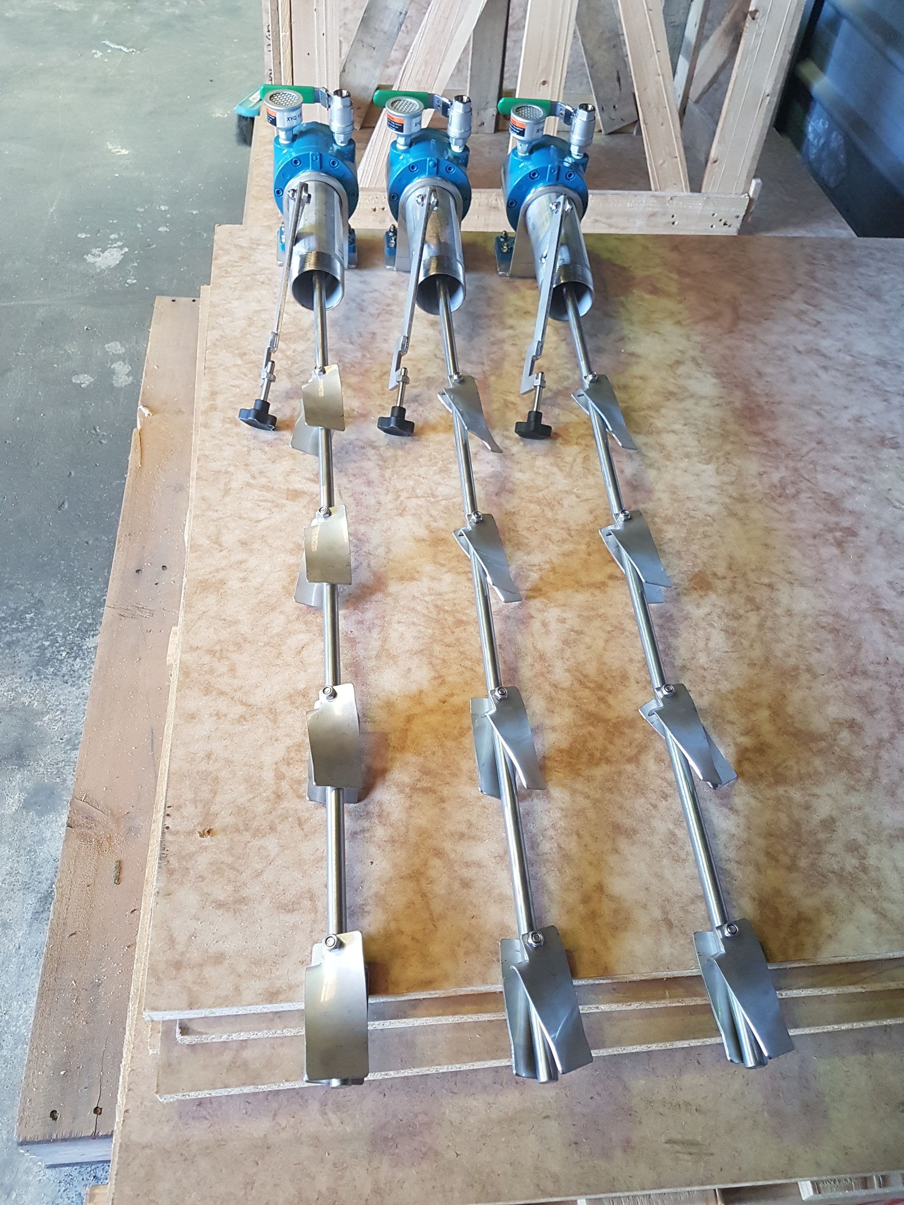Three FluidPro drum mixers in a row, with impellers visible and a clamp for attaching to the drum.