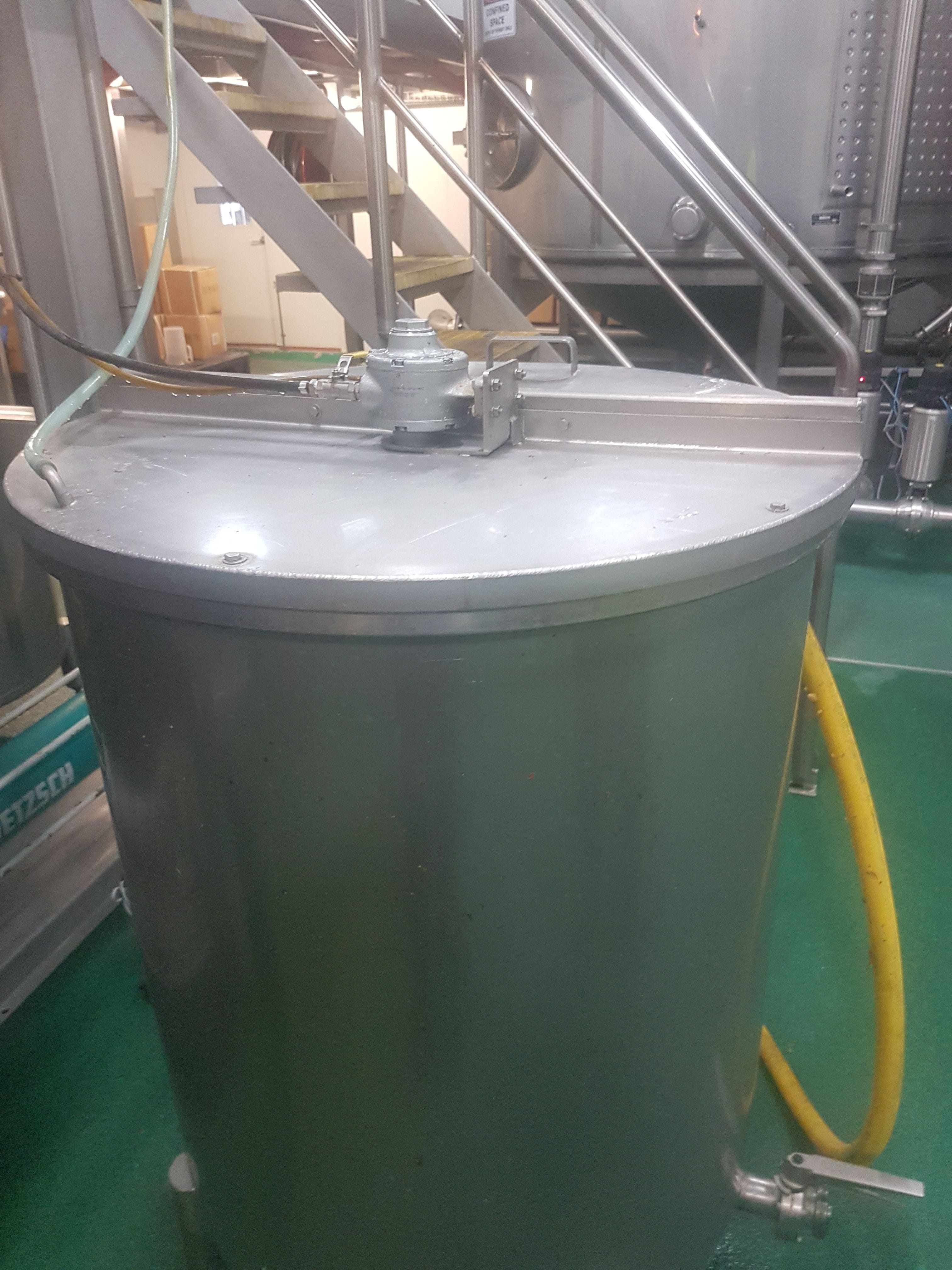 A DM-70 drum mixer mounted to a silver stainless steel drum.