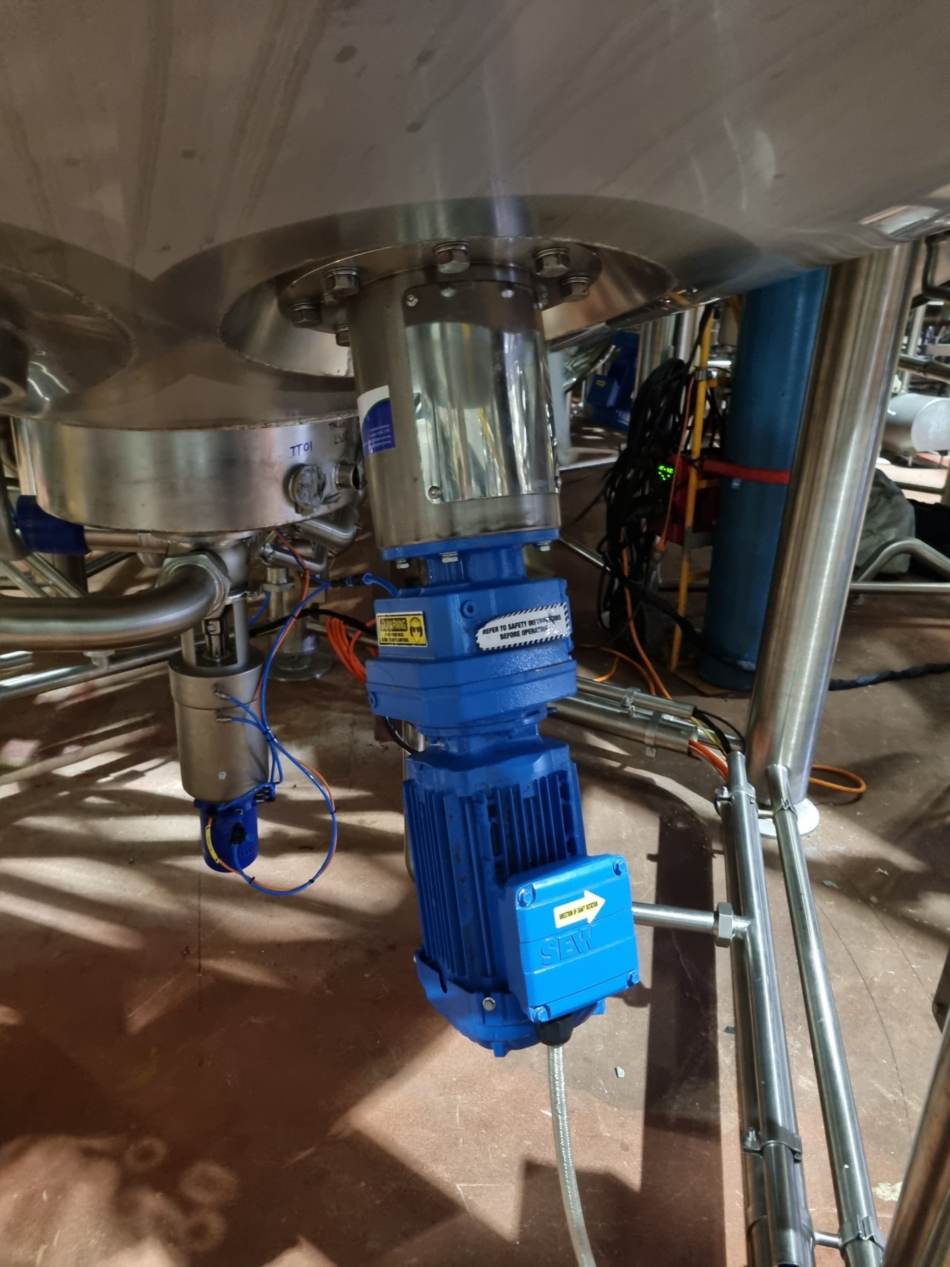 FluidPro BE-10 base entry mixer with contouted mounting flange visible at the base of a conical bottom stainless steel tank.