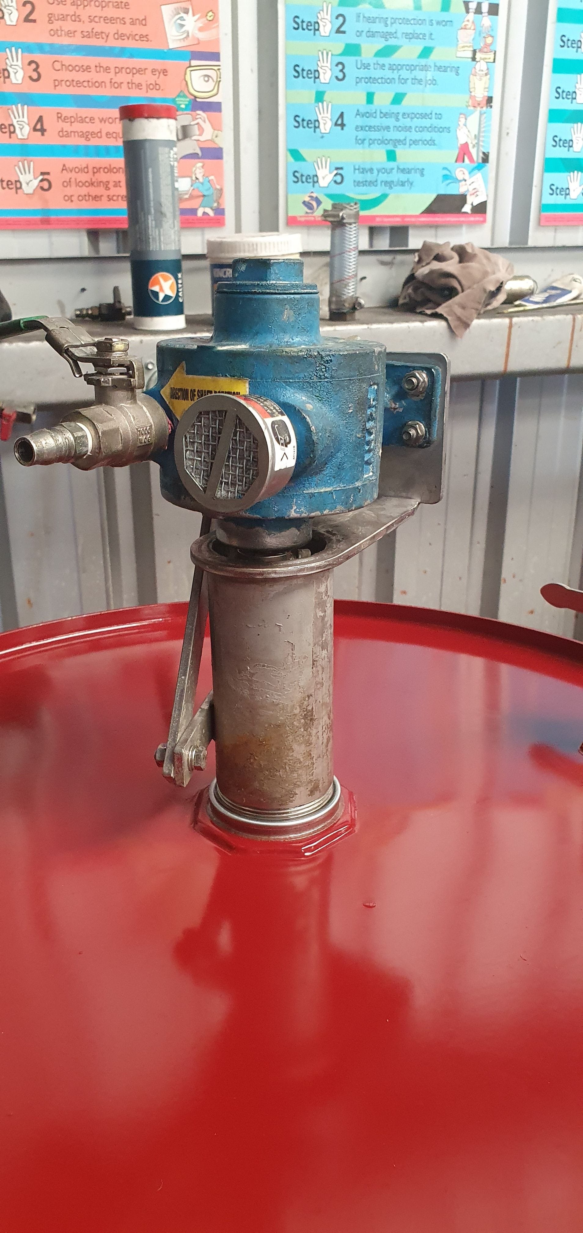 The air driven motor of a DM-50 drum mixer mounted to a red drum.